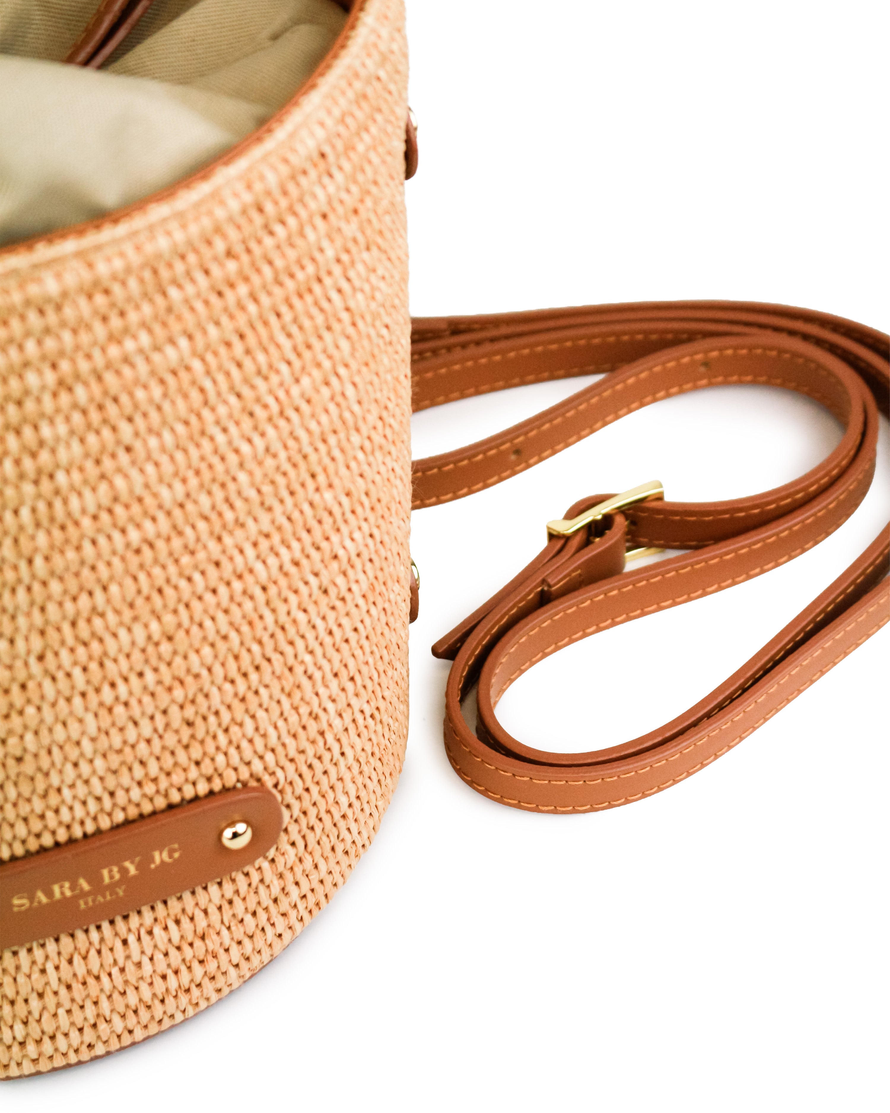 Raffia handbag La Raccolta showcasing a cylindrical shape with sophisticated raffia texture and leather strap.